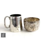 A hallmarked silver small mug with part engraved decoration and scroll handle, with a similar