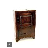 A 19th Century oak hanging cupboard enclosed by a fielded panelled door, on later bracket feet,
