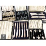 Two cased sets of six silver handled butter knives, with a cased set of six silver coffee bean