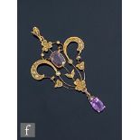 An early 20th Century 9ct amethyst and seed pearl open work pendant with two amethyst stones to a