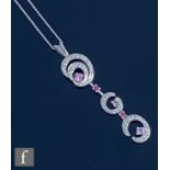 A modern 9ct white gold diamond, ruby and pink sapphire pendant, diamond set scrolls highlighted