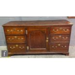 A small George III oak dresser base enclosed by a recessed central arch cupboard door flanked by