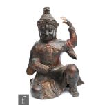 A Sino-Tibetan patinated cast metal figure of a warrior, modelled in kneeling position wearing