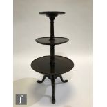 A mahogany graduated three-tier dumb waiter with turned pedestals and a tripod base, height 97cm and