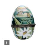 A Moorcroft Enamels egg shaped trinket box and cover decorated with a hand painted Easter scene with