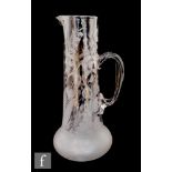 A late Victorian clear glass jug, the body of low shouldered form with shallow engraved floral