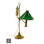 An early 20th Century brass library reading lamp, with green conical glass shade and adjustable
