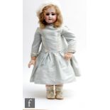 An unmarked bisque socket head doll, with fixed paperweight blue eyes, open mouth with teeth,