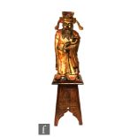 A Chinese carved and gilded wooden figure of a standing official wearing robes and holding a ruyi