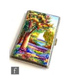 A 1930s white metal cigarette case decorated with a enamelled woodland scene with a lake in the