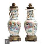 A pair of late 19th Century Chinese Canton famille rose vases of baluster form with everted rim, the
