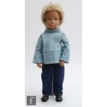 A Trendon Sasha doll with blonde hair, with short home haircut, wearing smock, jeans, white socks