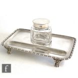 A hallmarked silver desk stand of rectangular plain form with egg and dart border supporting a