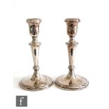 A pair of hallmarked silver candlesticks, circular stepped bases below plain flaring columns and