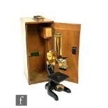 An Ernst Leitz brass microscope No 233143 in fitted oak case.