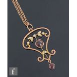 An early 20th Century 9ct garnet and seed pearl open work pendant, two garnets with foliate seed