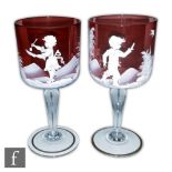 A pair of Mary Gregory style wine glasses with ruby bucket form bowl decorated with a stylised