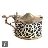 A hallmarked silver large oval mustard pot with pierced scroll decoration below plain hinged cover