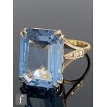 A 9ct hallmarked single stone blue topaz ring, emerald cut claw set stone, length 16mm, weight 5.4g,