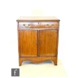 An early 20th century mahogany cabinet in the George IV style enclosed by a pair of doors below a