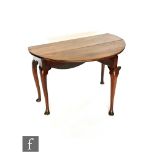 A George II fruitwood gate-leg table of circular form, with carved husk knees to the cabriole