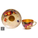 A Royal Worcester Fallen Fruits cup and saucer decorated by Freeman with hand painted peaches and
