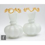 A pair of late 19th Century opal glass vases of footed and fluted ovoid form with a flared collar