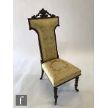 A Victorian rosewood prie dieu or prayer chair, upholstered in gold floral damask, on turned legs to