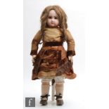 A late 19th Century Jumeau Bebe bisque socket head doll, with fixed brown paperweight eyes,