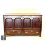 An 18th Century oak mule chest, the quadruple panel front below a hinged top over two short drawers,