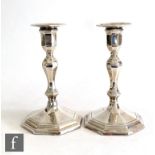 A pair of hallmarked silver piano candlesticks, hexagonal stepped bases below knop stems and