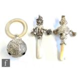 Three hallmarked silver and mother of pearl baby's rattles, one modelled as a seated dog, dated