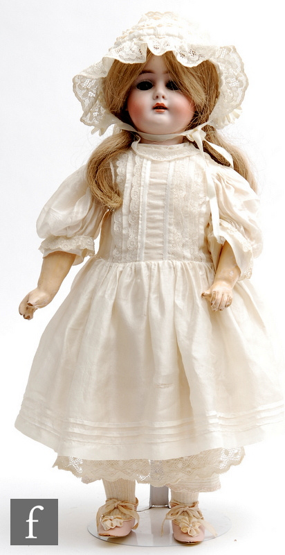 An unmarked German bisque socket head doll, with sleeping brown eyes, open mouth with teeth, painted