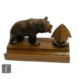 An early 20th Century Black Forest desk stand mounted with a carved bear and glass inkwell on a