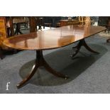 A Regency style rosewood crossbanded D end mahogany dining table with two extra leaves, on ring