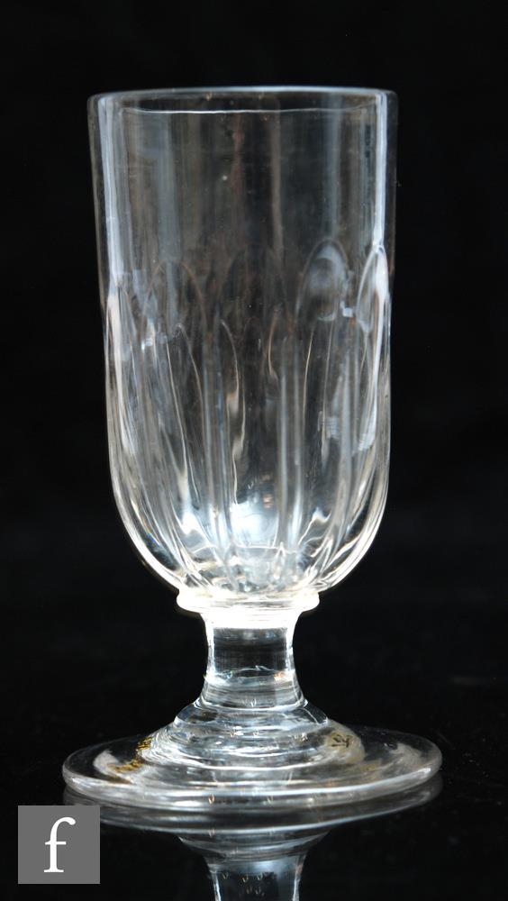 An 18th Century dwarf ale glass, the tall cup form bowl with basal moulded fluting above a capstan