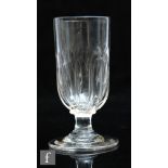 An 18th Century dwarf ale glass, the tall cup form bowl with basal moulded fluting above a capstan