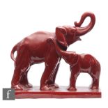 Charles Lemanceau - An Art Deco model of an elephant and her calf, both glazed in red, on a