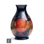 William Moorcroft - A small baluster form vase decorated in the Pomegranate pattern with a band of