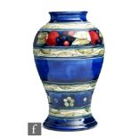 William Moorcroft - A vase of inverted baluster form decorated in the Banded Pomegranate pattern