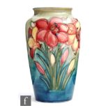 William Moorcroft - A vase of tapering form decorated in the African Lily pattern against a green