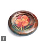 William Moorcroft - A small roll rim bowl or pin dish decorated in the Flambe African Lily