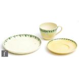Ruskin Pottery - A yellow lustre teacup, saucer and side plate (trio) decorated with a painted