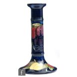 William Moorcroft - A candlestick of typical form decorated in the Wisteria pattern, impressed
