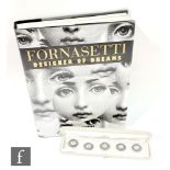 Fornasetti - A boxed set of five buttons with central face design on gilt backing, diameter 2.5cm,