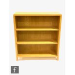 Ercol Furniture - A light oak Bosco range open fronted bookcase, with curved finger joint