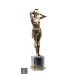 Unknown - An Art Deco bronze figure modelled as a female nude styling her hair, raised to a