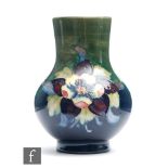 A Moorcroft vase of footed globe and shaft form decorated in the Columbine pattern, impressed mark