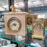 An early 20th Century alabaster mantle clock surmounted with a recumbent gilt lion, Arabic dial,