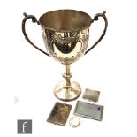 An engine turned silver cigarette case, a napkin ring, two plated cigarette cases and a trophy cup